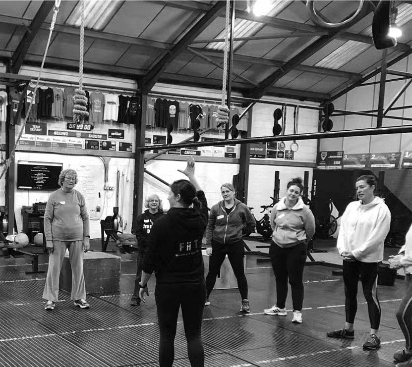 FiiTUK coach leading a group functional fitness session in a gym.